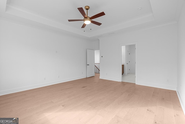 unfurnished bedroom with a raised ceiling, crown molding, ceiling fan, and light wood-type flooring