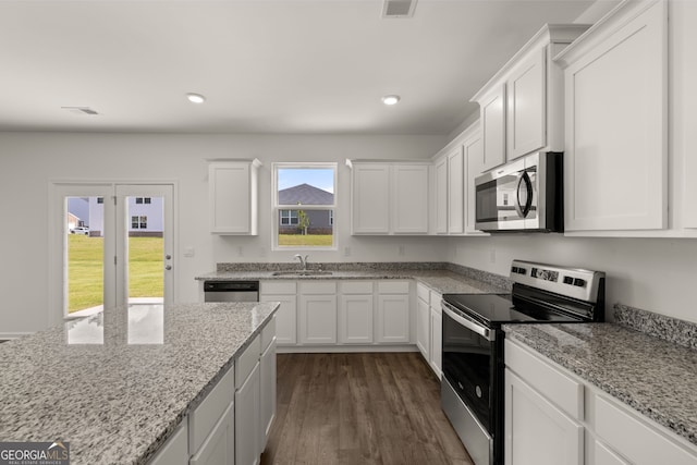 kitchen with white cabinetry, light stone countertops, dark hardwood / wood-style flooring, stainless steel appliances, and sink