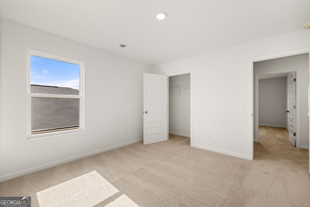 unfurnished bedroom featuring light carpet and a closet