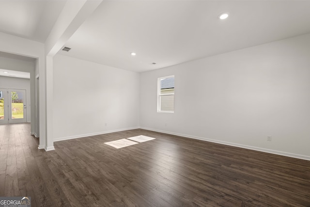 empty room with dark hardwood / wood-style floors and french doors