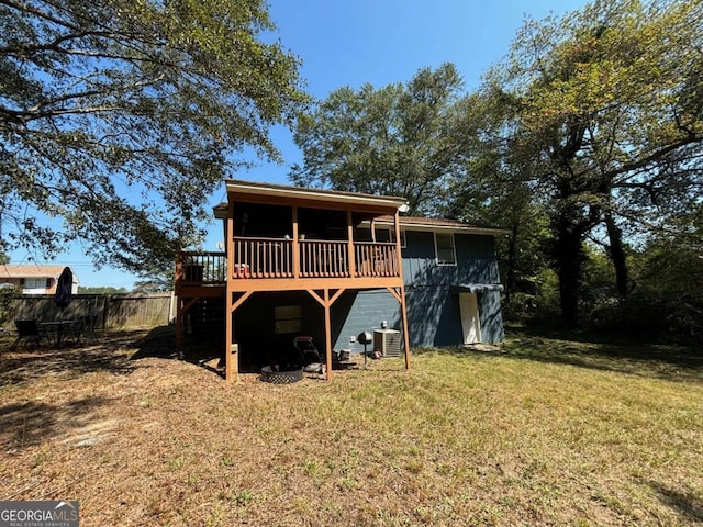 back of property featuring central air condition unit, a wooden deck, and a lawn