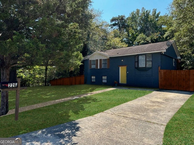 split foyer home with fence and a front lawn