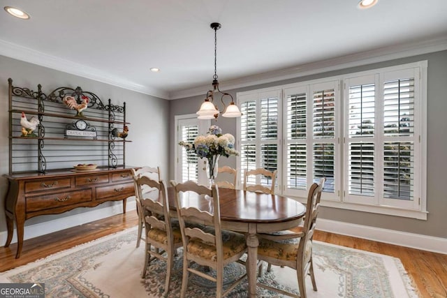 dining space with ornamental molding, hardwood / wood-style floors, and a healthy amount of sunlight