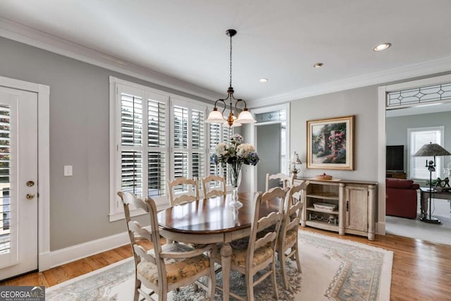 dining space with ornamental molding, light wood-type flooring, and plenty of natural light