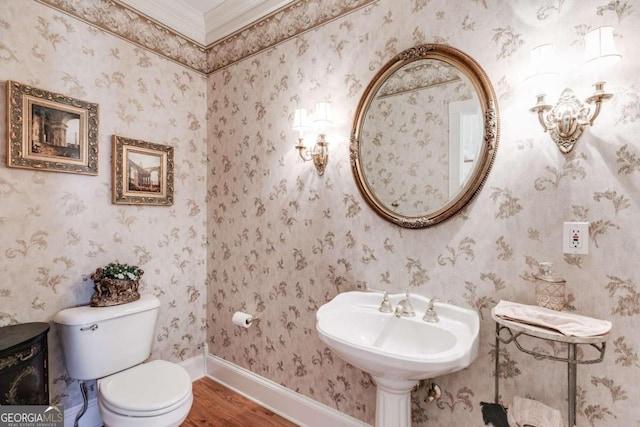 bathroom with hardwood / wood-style floors, ornamental molding, and toilet