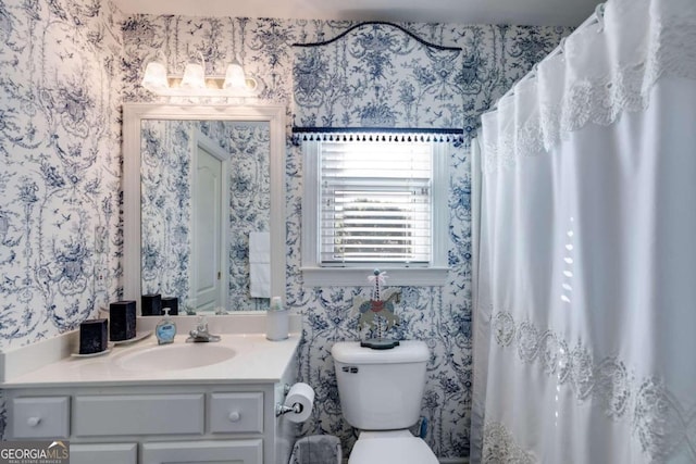 bathroom with a shower with shower curtain, vanity, and toilet