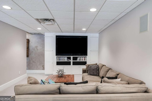 living room featuring a paneled ceiling and carpet flooring