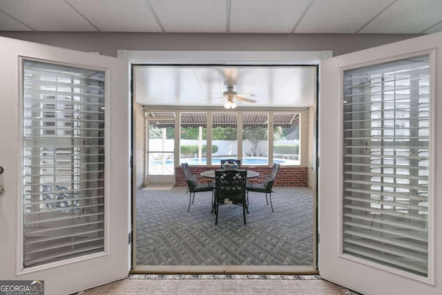 dining space featuring carpet floors, a paneled ceiling, and ceiling fan