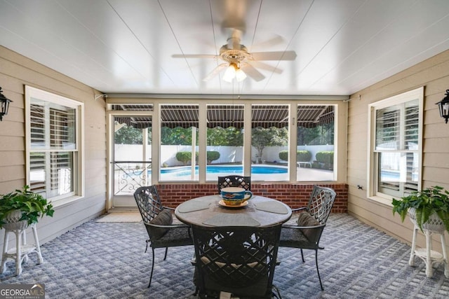 sunroom featuring ceiling fan and plenty of natural light