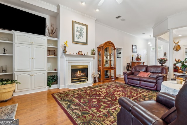 living room with ornamental molding, light hardwood / wood-style flooring, and ornate columns