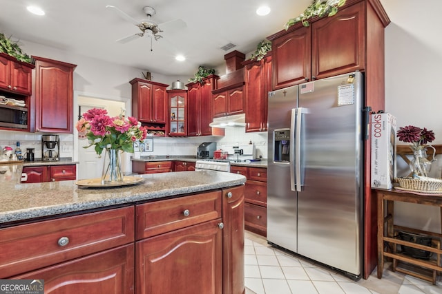 kitchen featuring backsplash, ceiling fan, stainless steel appliances, and light stone counters