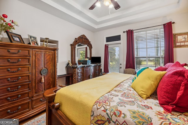 bedroom featuring a tray ceiling, ceiling fan, and access to exterior