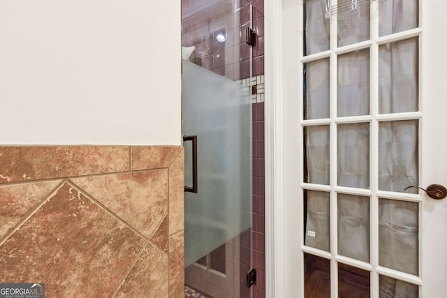 bathroom featuring a shower and tile walls