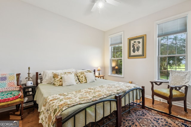 bedroom featuring ceiling fan, multiple windows, and hardwood / wood-style floors