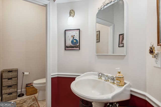 bathroom featuring tile patterned flooring, toilet, and sink