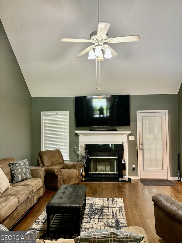 living room featuring hardwood / wood-style floors, vaulted ceiling, and ceiling fan