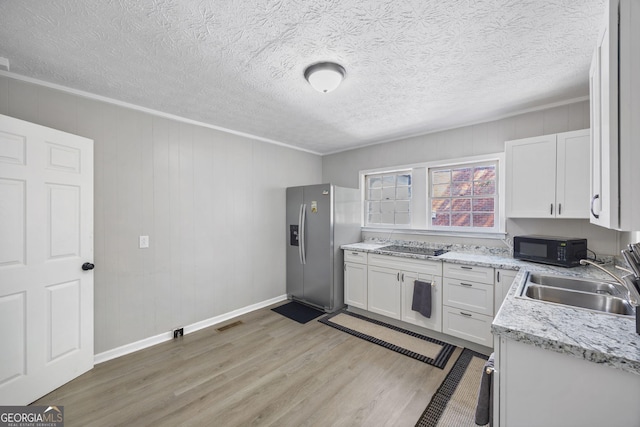 kitchen featuring sink, light hardwood / wood-style flooring, stainless steel refrigerator with ice dispenser, light stone countertops, and white cabinets