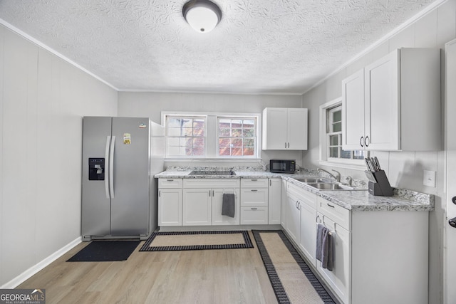 kitchen featuring sink, white cabinetry, light hardwood / wood-style flooring, light stone countertops, and black appliances