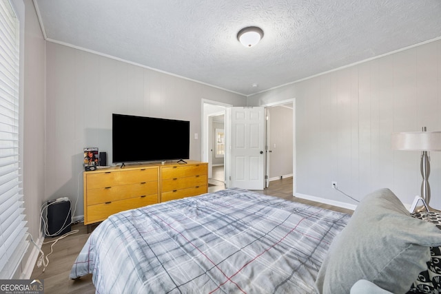 bedroom featuring ornamental molding, dark wood-type flooring, and a textured ceiling