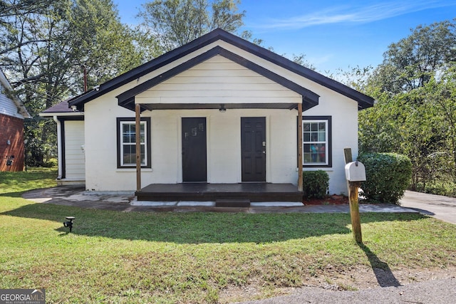 view of front of property with covered porch and a front yard