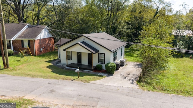 view of front of property featuring a porch, central AC unit, and a front yard