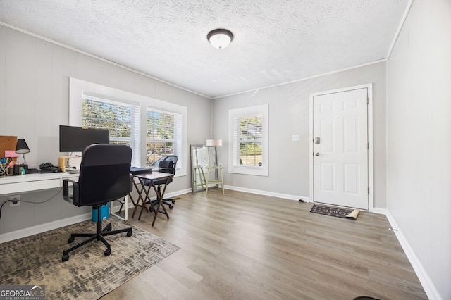 office space featuring crown molding, wood-type flooring, and a textured ceiling