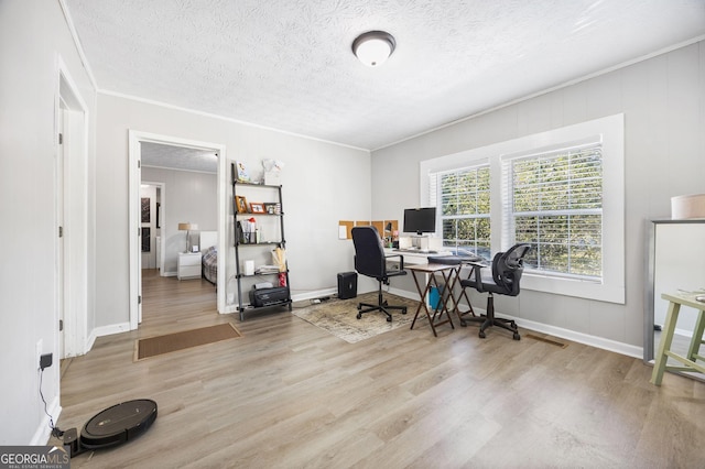 office space featuring ornamental molding, a textured ceiling, and light wood-type flooring