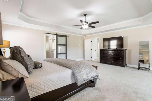 bedroom featuring a barn door, a tray ceiling, ceiling fan, and light colored carpet