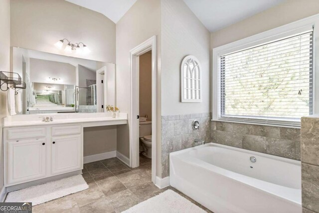 full bathroom with shower with separate bathtub, vanity, toilet, and vaulted ceiling