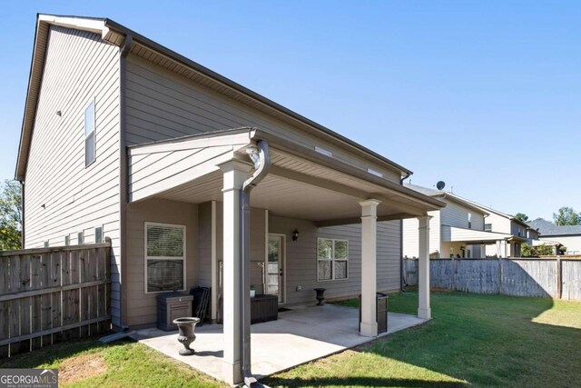 rear view of house featuring a yard and a patio area