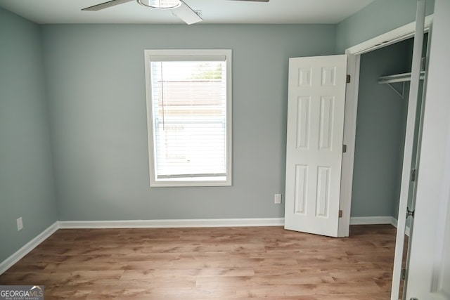 unfurnished bedroom featuring a closet, light hardwood / wood-style floors, and ceiling fan