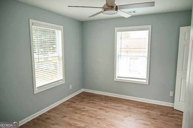 spare room with light hardwood / wood-style flooring, ceiling fan, and plenty of natural light