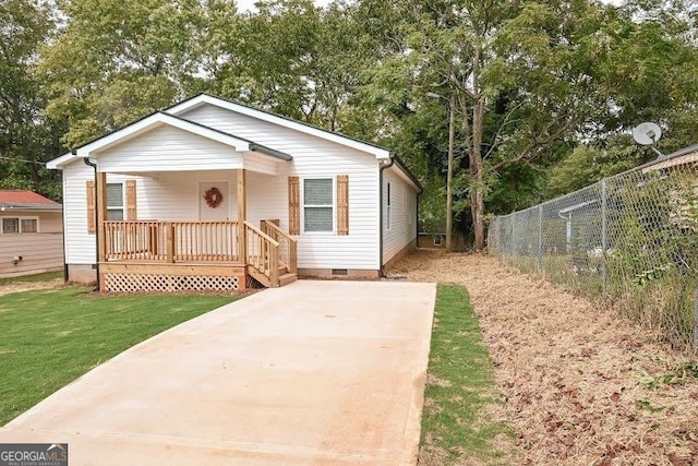 view of front facade featuring a front lawn, crawl space, covered porch, and fence