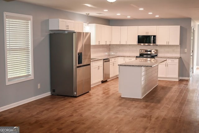 kitchen featuring pendant lighting, a center island, appliances with stainless steel finishes, and white cabinetry