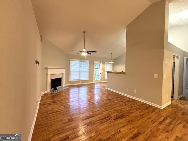 unfurnished living room featuring hardwood / wood-style floors, ceiling fan, a premium fireplace, and high vaulted ceiling