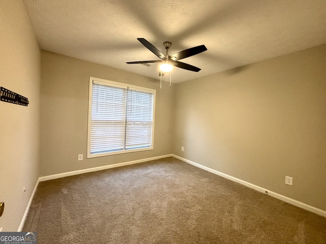 carpeted empty room featuring ceiling fan and a textured ceiling