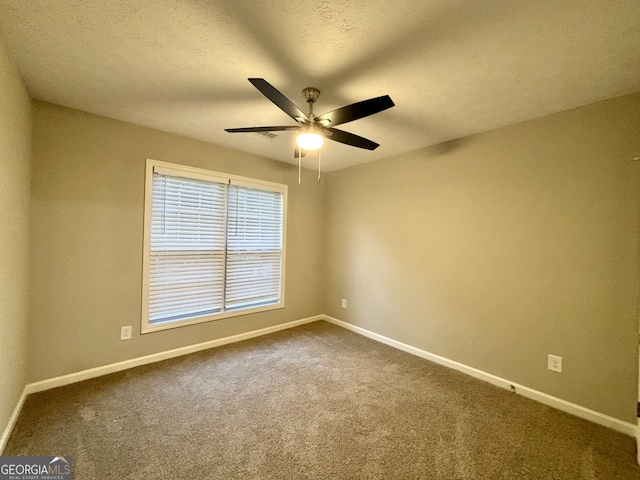 carpeted empty room featuring ceiling fan and a textured ceiling