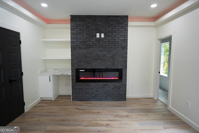 unfurnished living room featuring light hardwood / wood-style flooring and a fireplace