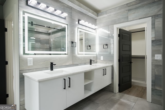 bathroom with tile walls, walk in shower, and vanity