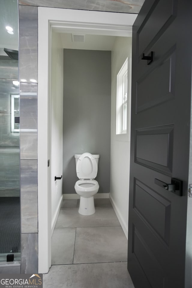 bathroom with toilet and tile patterned floors