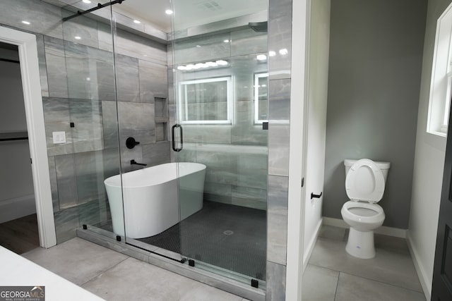 bathroom with shower with separate bathtub, tile patterned flooring, and toilet