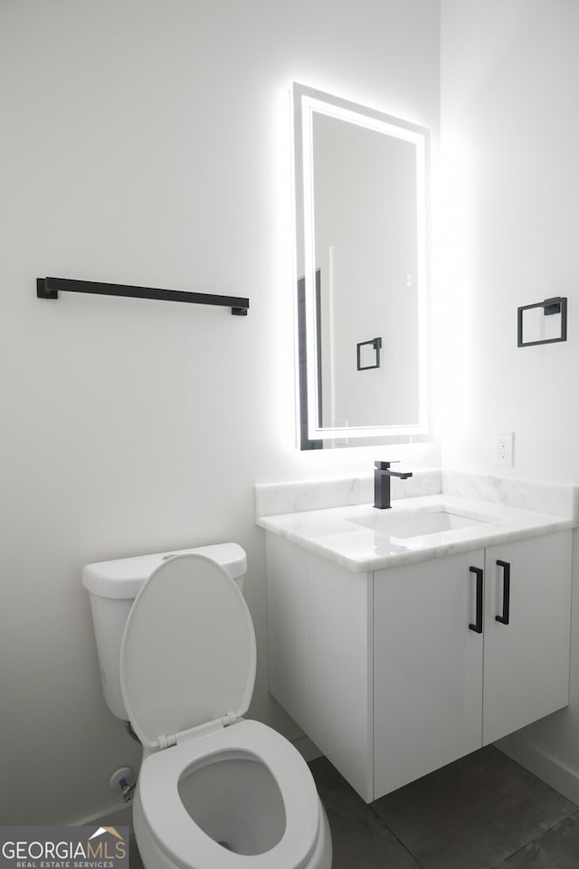 bathroom with vanity, toilet, and tile patterned floors