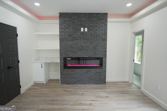 interior space with light wood-type flooring and a large fireplace