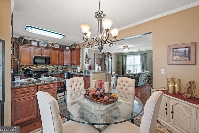 dining space with a textured ceiling, crown molding, ceiling fan with notable chandelier, and hardwood / wood-style floors