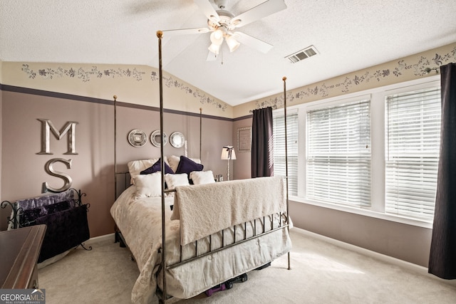 carpeted bedroom with a textured ceiling, vaulted ceiling, and ceiling fan