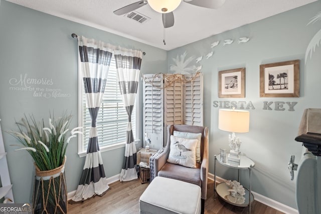 sitting room with hardwood / wood-style floors, ceiling fan, and a healthy amount of sunlight