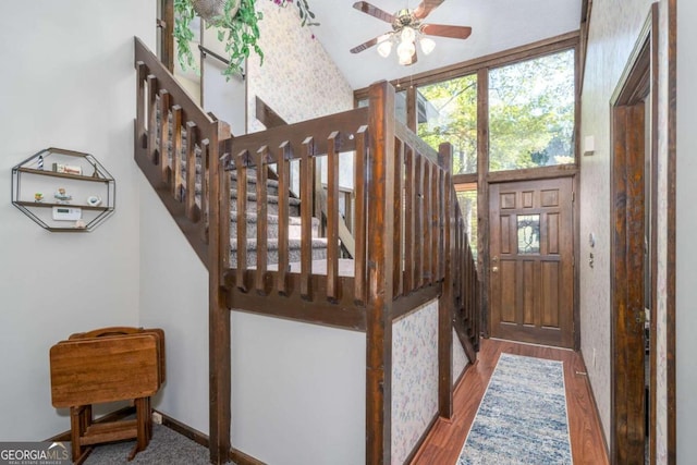 stairway with wood-type flooring and ceiling fan