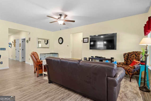 living room with light wood-type flooring and ceiling fan