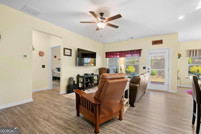 living room with light hardwood / wood-style floors and ceiling fan