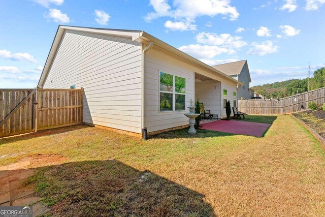 view of home's exterior featuring a patio area and a lawn